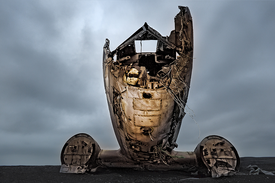 Ruined fuselage of WWII US Navy Plane on black sand beach in Iceland.