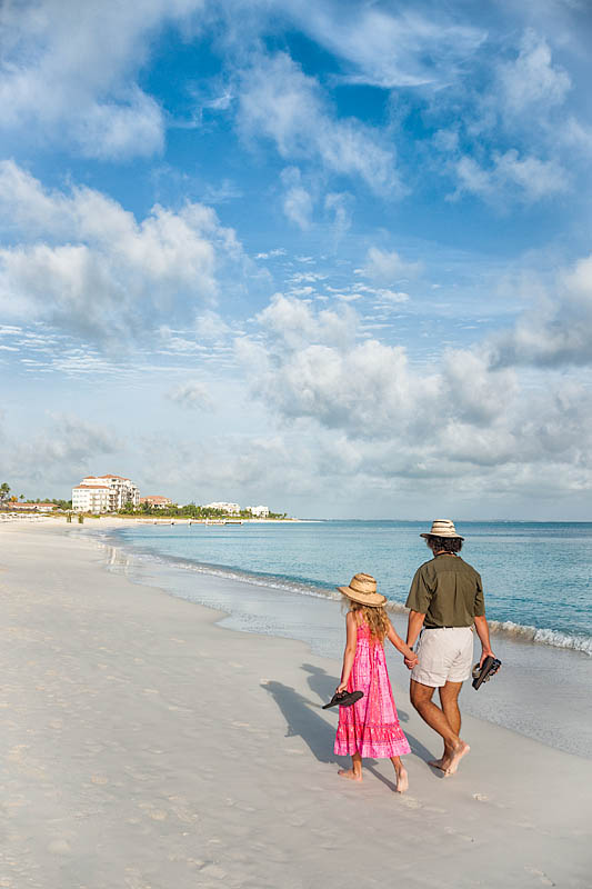 Father and daughter walking along Caribbean beach, Providenciales, Caicos, Turks & Caicos Islands