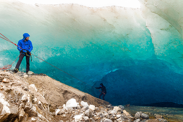 Male guide watches a peron rappel into an ice cave on a trekking adventure on Lemon Glacier, Juneau Icefield, Juneau, Alaska, USA