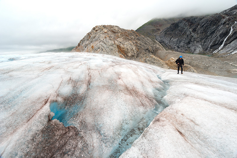 Man hikes over sloping ice on Lemon Glacier, Juneau Icefield, Juneau, Alaska, USA