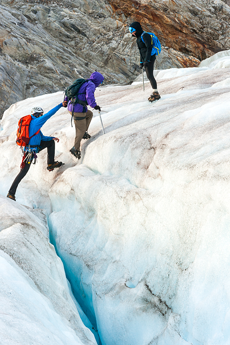 Ascending slippery ice near a crevasse during a trekking adventure on Lemon Glacier, Juneau 