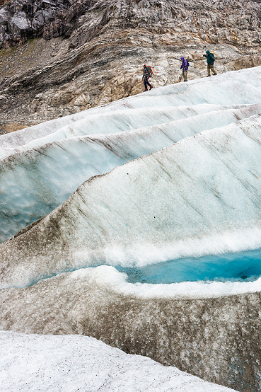 Trekking adventure on Lemon Glacier,Trio descend ice ridges past steep crevasses, Juneau Icefield, Juneau, Alaska, USA