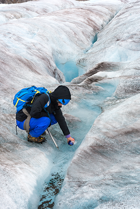 Man jumps over crevasse while trekking adventure on Lemon Glacier, Juneau Icefield, Juneau, Alaska, USA