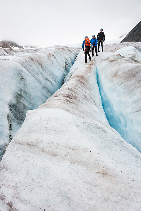 people walk between deep crevasse while trekking adventure on Lemon Glacier, Juneau Icefield, Juneau, Alaska, USA