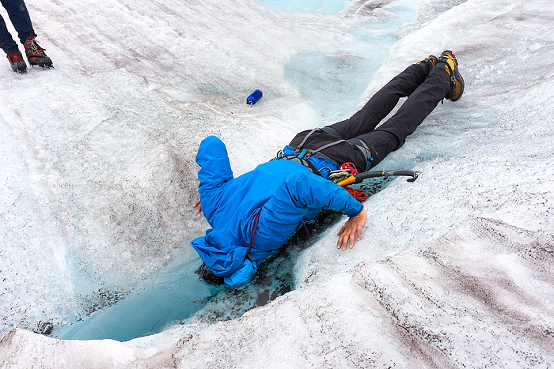 polar plunge in glacier water, Man jumps over crevasse while trekking adventure on Lemon Glacier, Juneau Icefield, Juneau, Alaska, USA