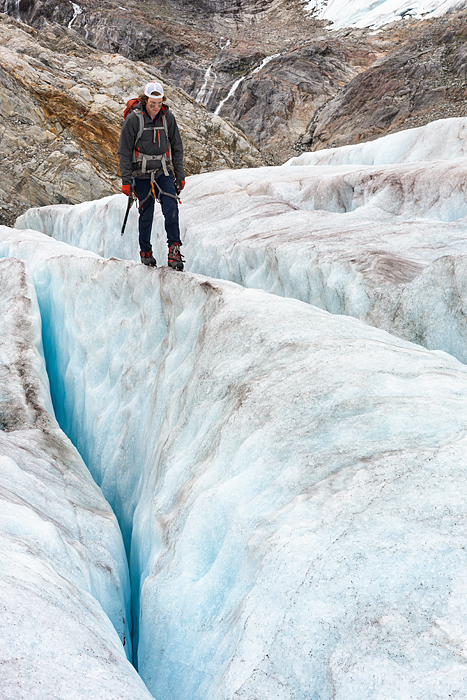 Man jumps over crevasse while trekking adventure on Lemon Glacier, Juneau Icefield, Juneau, Alaska, USA