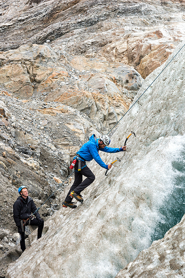 guide demonstrates ice climbing